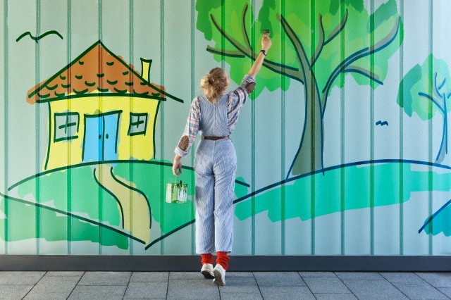 Street artist painting on wall